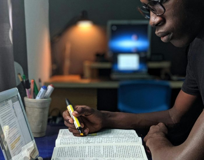 pexels photo 2574616 2574616 Man deeply engaged in studying with a book and tablet at a desk